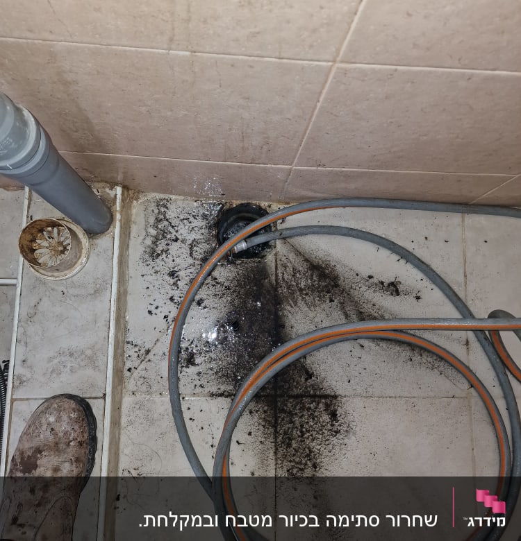 צינור ניקוז על רצפה מלוכלכת עם לכלוך שחור